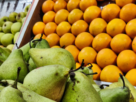 Fresh green pears and oranges on a market stallの写真素材