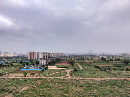 Picture of aerial view of the city scape. Farm land and buildings in background against cloudy skyの写真素材
