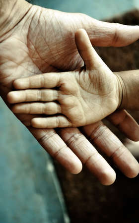 closeup of a child's hand on top of an adult'sの写真素材
