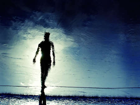 reflection of man's silhouete in the beachの写真素材