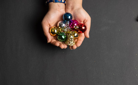 Christmas Balls, Crop view of young girl hand holding christmas balls isolated in black background for christmas decoration.の写真素材