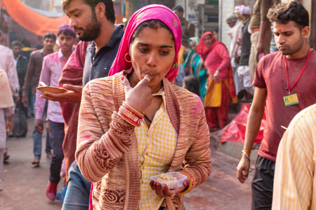 BARSANA, UTTAR PRADESH / INDIA - MARCH 2020: People celebrate the traditional and a ritualistic colorful Lathmar Holi with dance and colored faces at Radharani templeのeditorial素材