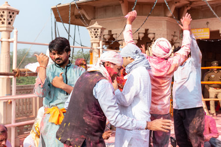 BARSANA, UTTAR PRADESH / INDIA - MARCH 2020: People celebrate the traditional and a ritualistic colorful Lathmar Holi with dance and colored faces at Radharani templeのeditorial素材