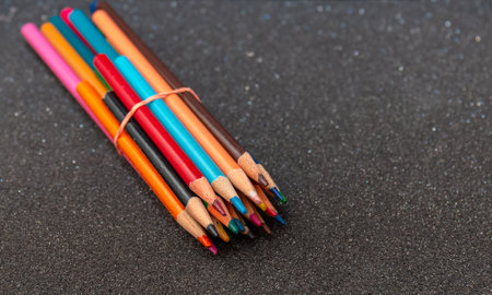 Multi color pencils isolated on black background. Close up shot.