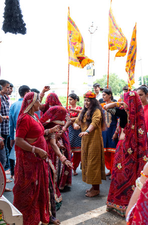 Khatu Shyam, Rajasthan / India - August 2019 : Beautiful Rajasthani women in traditional red sari and jewelry Holy with Veil performing march parade by bare footのeditorial素材