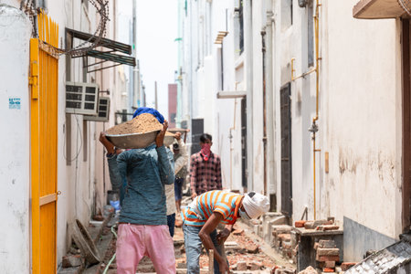 GHAZIABAD, UTTAR PRADESH / INDIA - JUNE 2020 : Young Indian male labor working at construction site with having Medical Mask on his face to prevent from Virus and Dustのeditorial素材