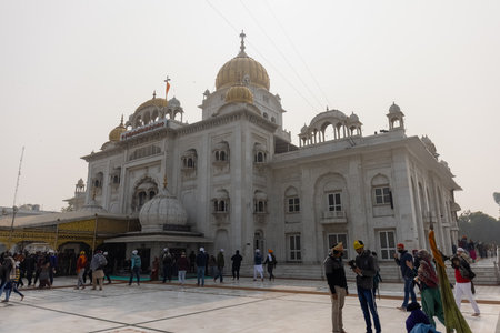 NEW DELHI, INDIA - JANUARY 2021 : Gurdwara Bangla Sahib is the most prominent Sikh gurdwara. One of the main attractions of new Delhi. Sikh pilgrims sitting in front of Gurdwara Bangla Sahib.のeditorial素材