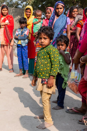 NOIDA, UTTAR PRADESH, INDIA - NOV 2020 : Portrait of poor kids or students from slum or village area standing in school ground to collect food distributed by volunteers during corona pandemic.のeditorial素材