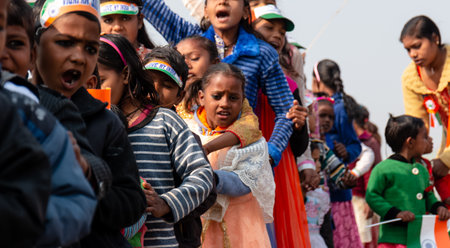 NOIDA, UTTAR PRADESH, INDIA - JANUARY 2020 : Young Indian students from Slum or Village area celebrating Indian Republic Day function at school with Indian National flag in hand.のeditorial素材