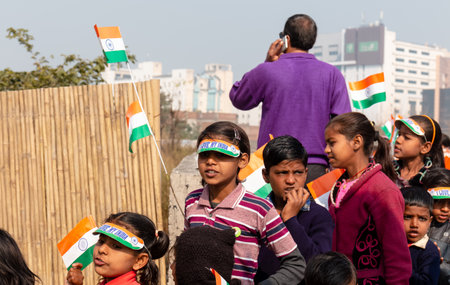 NOIDA, UTTAR PRADESH, INDIA - JANUARY 2020 : Young Indian students from Slum or Village area celebrating Indian Republic Day function at school with Indian National flag in hand.のeditorial素材