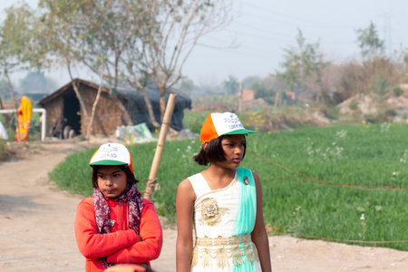 NOIDA, UTTAR PRADESH, INDIA - JANUARY 2020 : Young Indian students from Slum or Village area celebrating Indian Republic Day function at school with Indian National flag in hand.のeditorial素材