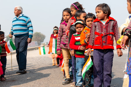 NOIDA, UTTAR PRADESH, INDIA - JANUARY 2020 : Young Indian students from Slum or Village area celebrating Indian Republic Day function at school with Indian National flag in hand.のeditorial素材