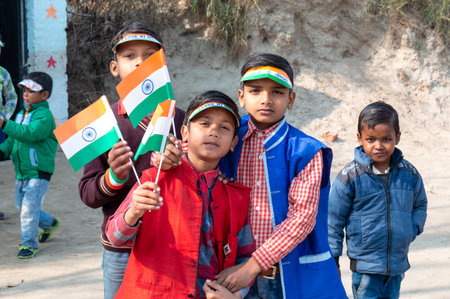NOIDA, UTTAR PRADESH, INDIA - JANUARY 2020 : Young Indian students from Slum or Village area celebrating Indian Republic Day function at school with Indian National flag in hand.のeditorial素材