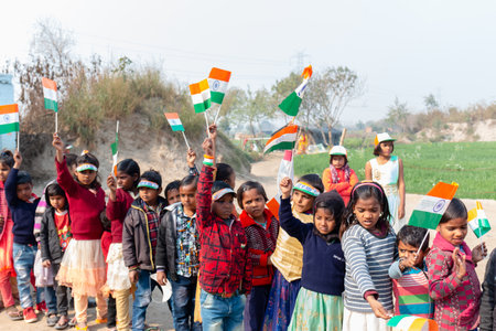 NOIDA, UTTAR PRADESH, INDIA - JANUARY 2020 : Young Indian students from Slum or Village area celebrating Indian Republic Day function at school with Indian National flag in hand.のeditorial素材
