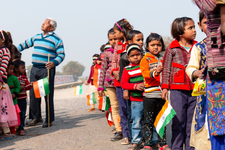 NOIDA, UTTAR PRADESH, INDIA - JANUARY 2020 : Young Indian students from Slum or Village area celebrating Indian Republic Day function at school with Indian National flag in hand.のeditorial素材
