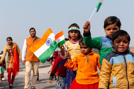 NOIDA, UTTAR PRADESH, INDIA - JANUARY 2020 : Young Indian students from Slum or Village area celebrating Indian Republic Day function at school with Indian National flag in hand.のeditorial素材