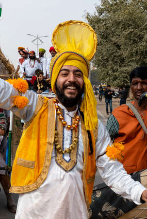 BIKANER, RAJASTHAN, INDIA - JANUARY 2019 : Group of Sikh male artist performing Punjabi Bhangra dance in colorful Yellow and Blue traditional dress on the streets on Bikaner city.のeditorial素材