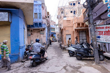 JODHPUR, RAJASTHAN, INDIA - JULY 2021: The bright blue color street and houses of the blue city in...