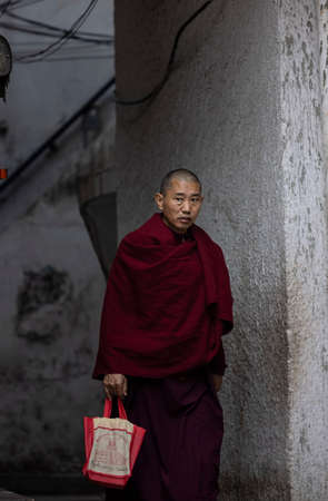 New Delhi, India - December 2021: Portrait of Indian tibetan monk lama in red color clothing  at tibetan monastery area.のeditorial素材