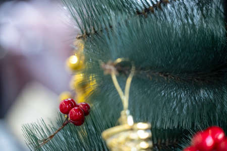 Decorated Christmas tree with gifts, red cherry and Christmas ball with colorful bokeh.