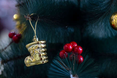 Decorated Christmas tree with gifts, red cherry and Christmas ball with colorful bokeh.の写真素材