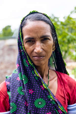 Jawai, Rajasthan, India - September 2021: Portrait of Indian woman working at construction site in ethnic rajasthani dress. Indian labour at working site.のeditorial素材