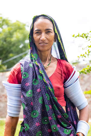 Jawai, Rajasthan, India - September 2021: Portrait of Indian woman working at construction site in ethnic rajasthani dress. Indian labour at working site.のeditorial素材