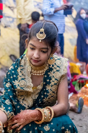 Ghaziabad, Uttar Pradesh, India - November 2021: Chhath Puja, Indian hindu devotees performing rituals of chhath puja during sunrise near river bank.のeditorial素材