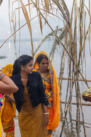 Ghaziabad, Uttar Pradesh, India - November 2021: Chhath Puja, Indian hindu devotees performing rituals of chhath puja during sunrise near river bank.のeditorial素材