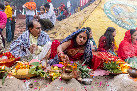 Ghaziabad, Uttar Pradesh, India - November 2021: Chhath Puja, Indian hindu devotees performing rituals of chhath puja during sunrise near river bank.のeditorial素材