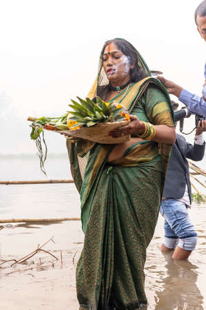 Ghaziabad, Uttar Pradesh, India - November 2021: Chhath Puja, Indian hindu devotees performing rituals of chhath puja during sunrise near river bank.のeditorial素材