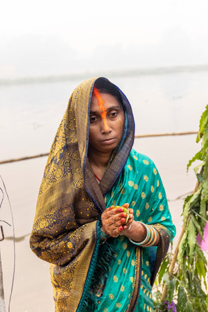 Ghaziabad, Uttar Pradesh, India - November 2021: Chhath Puja, Indian hindu devotees performing rituals of chhath puja during sunrise near river bank.のeditorial素材