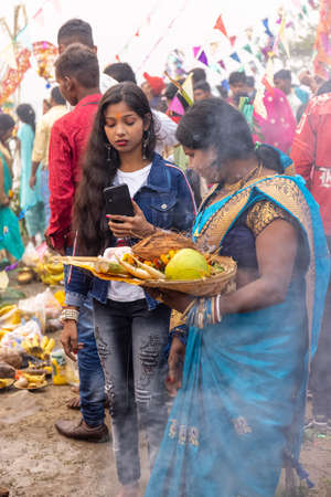 Ghaziabad, Uttar Pradesh, India - November 2021: Chhath Puja, Indian hindu devotees performing rituals of chhath puja during sunrise near river bank.のeditorial素材