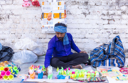 Anandpur Sahib, Punjab, India - March 2022: Portrait of sikh male selling plastic toys for survival on the streets of Anandpur Sahib during the holi festival. Selective focus on huのeditorial素材