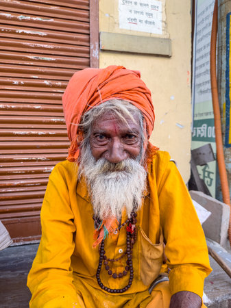 Pushkar, Rajasthan, India - November 2022: Portrait of an old  sadhu baba on the street of Pushkar in traditional saffron dress with white beard.のeditorial素材