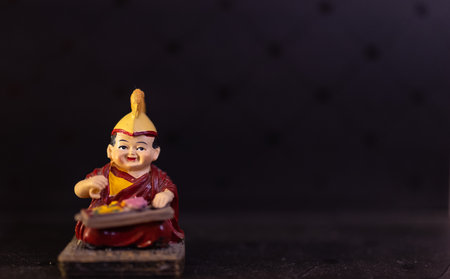 Clay Buddha statuette on black background with copy space.の写真素材