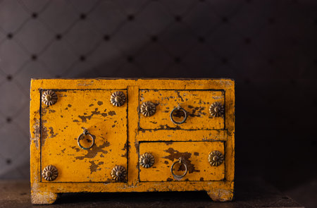 Vintage wooden chest of drawers on a dark background close upの写真素材