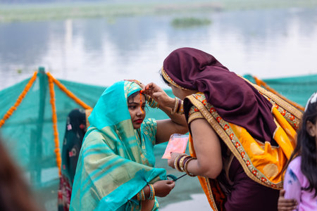Ghaziabad, Uttar Pradesh, India - October 2022: Chhath Puja, Indian hindu female devotee performing rituals of chhath puja while standing in river to worship lord sun during sunsetのeditorial素材
