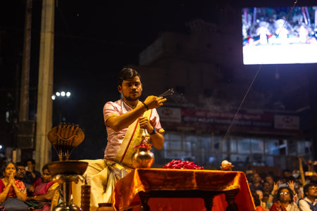 Varanasi, Uttar Pradesh, India - March 03 2023: Ganga aarti, Portrait of young priest performing holy river ganges evening aarti at dashashwamedh ghat in varanasi.のeditorial素材