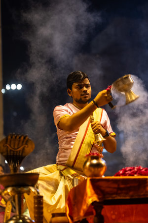 Varanasi, Uttar Pradesh, India - March 03 2023: Ganga aarti, Portrait of young priest performing...