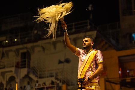 Varanasi, Uttar Pradesh, India - March 03 2023: Ganga aarti, Portrait of young priest performing holy river ganges evening aarti at dashashwamedh ghat in traditional dress.のeditorial素材