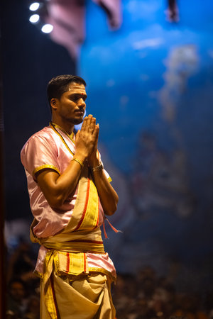 Varanasi, Uttar Pradesh, India - March 03 2023: Ganga aarti, Portrait of young priest performing holy river ganges evening aarti at dashashwamedh ghat in traditional dress.のeditorial素材