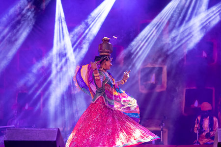 Pushkar, Rajasthan, India - November 2022: An female artist performing rajasthani folk dance Ghoomar in traditional colorful dress and metal pot with fire on head in Pushkar fair.のeditorial素材