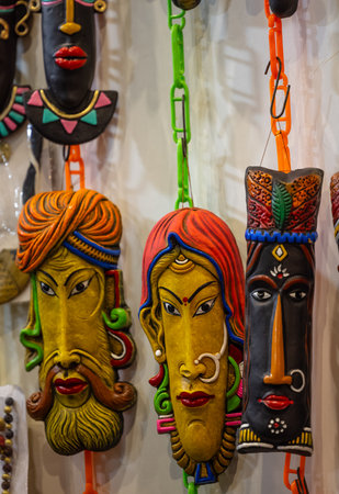 Colorful wooden masks on display at a souvenir shopの写真素材