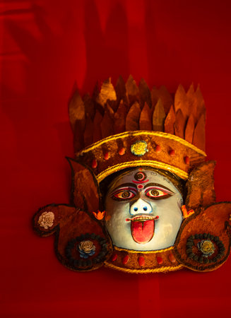 Handmade colorful face mask souvenir hanging on plain black background. Selective focus on object.の写真素材