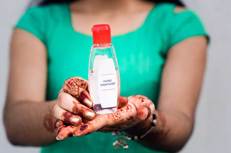 Young girl holding the alcohol  based hand sanitizer gel bottle. Hand sanitizer used to prevent harmful virus and Prevent covid-19 virus.の写真素材