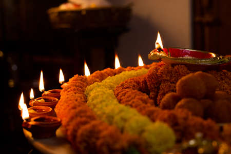 Diwali glowing Diya , flowers, Sweets and Gifts arranged in circular shape forming a design with...
