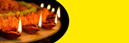 Diwali glowing Diya , flowers, Sweets and Gifts arranged in circular shape forming a design with copy space, selective focus , Indian festivalの写真素材