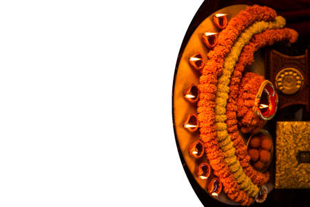 Diwali glowing Diya and flowers arranged in circular shape forming a design with copy space,...
