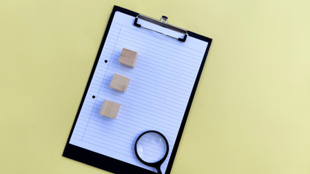 clipboard and magnifying glass on yellow backgroundの写真素材